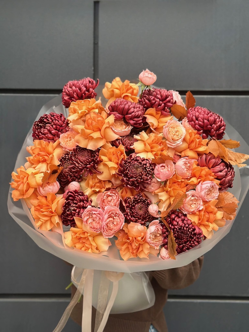 Букет из 15 ярко-коралловых роз с зеленью